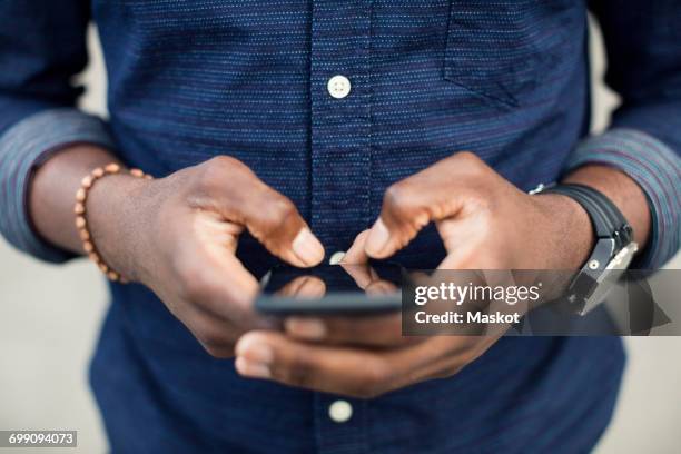 midsection of man using mobile phone - hand mobile stock-fotos und bilder