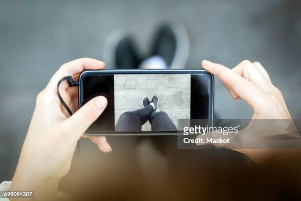 midsection of woman photographing legs - horizontal stock-fotos und bilder
