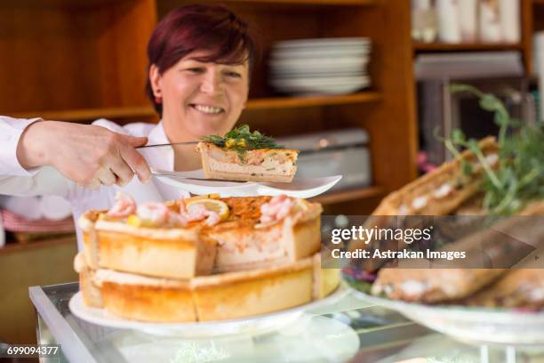 sweden, stockholm, gamla stan, smiling woman serving tart in cafe - fika stock pictures, royalty-free photos & images