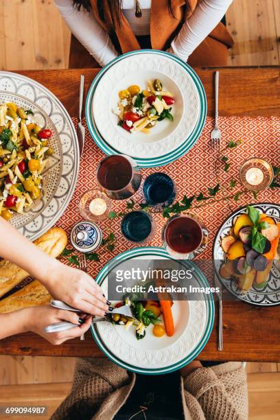 cropped image of womans hands serving food to friends at table - wine glass finger food stock-fotos und bilder