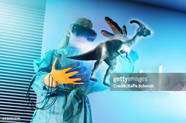 girl in virtual reality headset interacting with digital floating dinosaur - augmented reality animal stock-fotos und bilder