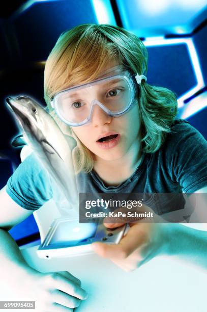 boy with hand held computer staring at digital jumping dolphin - augmented reality animal stock-fotos und bilder