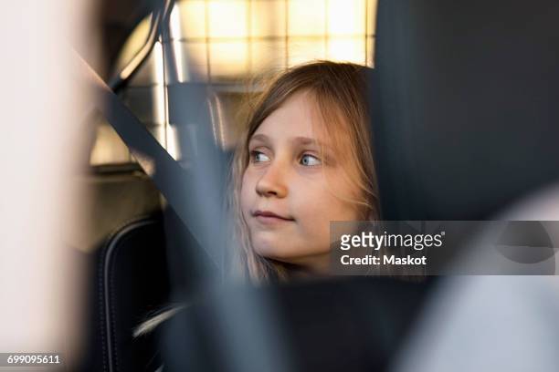 blond girl sitting in electric car - back seat stock pictures, royalty-free photos & images