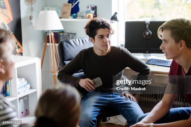 siblings talking to friend while sitting in bedroom - refugee icon stock pictures, royalty-free photos & images