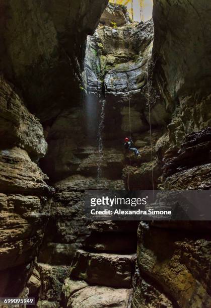 man rappels into large mouthed cave in alabama - spelunking stockfoto's en -beelden