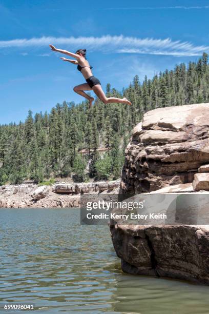 two young women cliff jumping in the blue ridge reservoir, coconino national forest, arizona - kerry estey keith - fotografias e filmes do acervo
