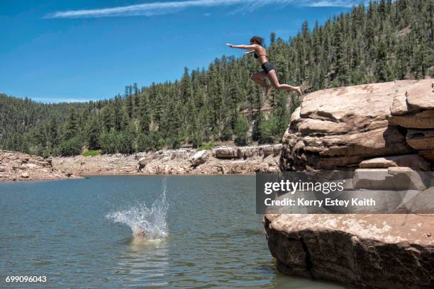 two young women cliff jumping in the blue ridge reservoir, coconino national forest, arizona - cliff jumping stock pictures, royalty-free photos & images