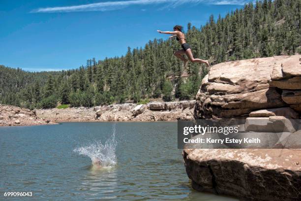 two young women cliff jumping in the blue ridge reservoir, coconino national forest, arizona - kerry estey keith - fotografias e filmes do acervo