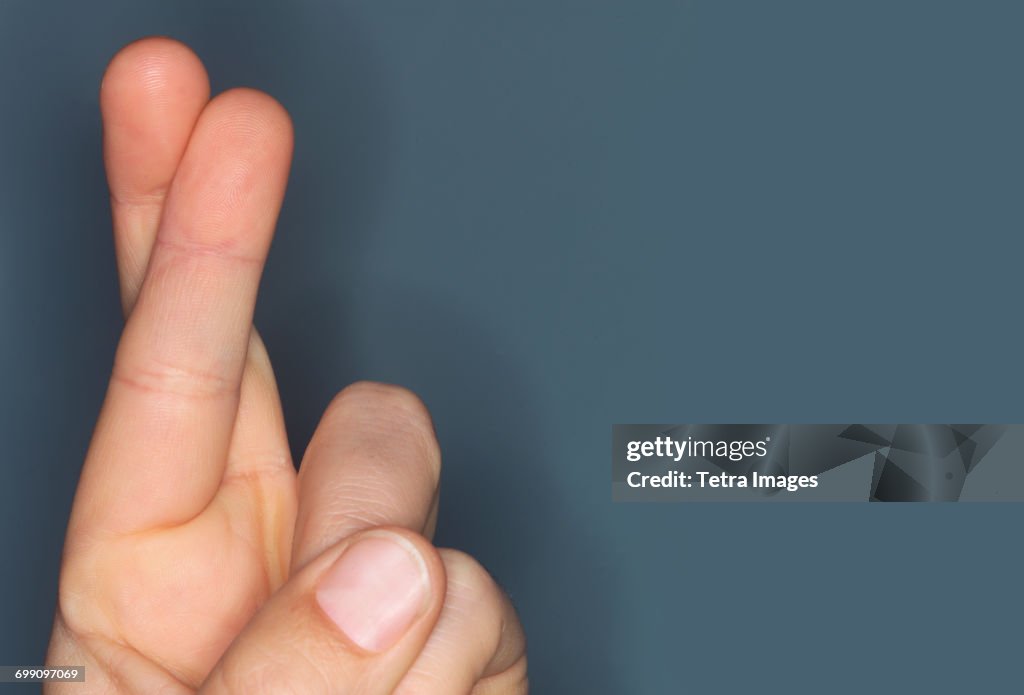 Close-up of hand with fingers crossed