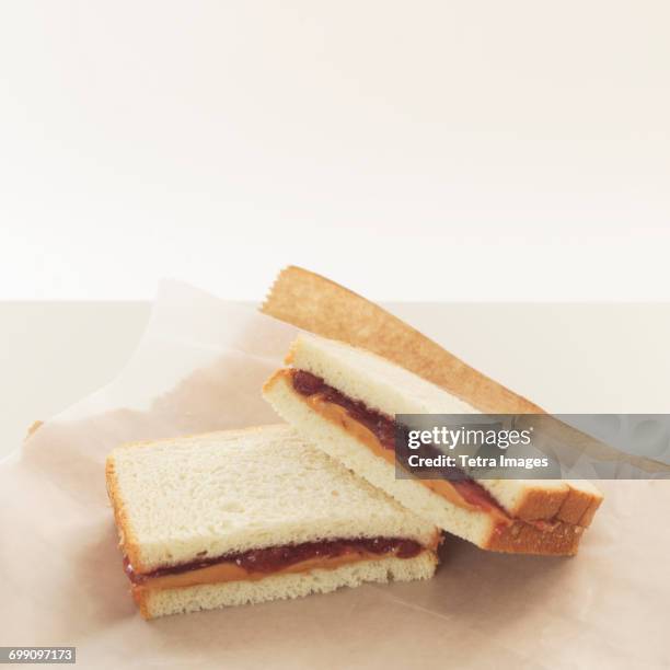 peanut butter and jelly sandwiches on wrapping paper - peanut butter and jelly stockfoto's en -beelden