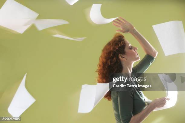 mature woman scattering papers around herself - throwing paper stock pictures, royalty-free photos & images