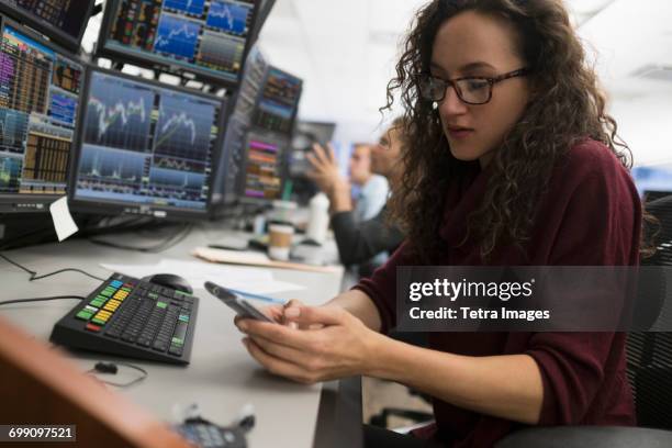 young trader using mobile phone - börsensaal stock-fotos und bilder