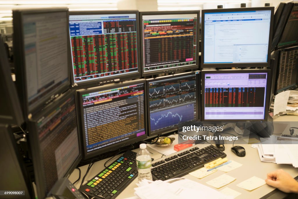 Young man working on group of computer monitors