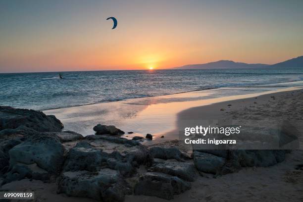 silhouette of a man kitesurfing, los lances beach, tarifa, cadiz, andalucia, spain - tarifa stock pictures, royalty-free photos & images
