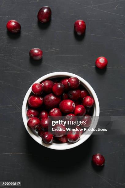 cranberries in bowl and on table - cranberries stock pictures, royalty-free photos & images