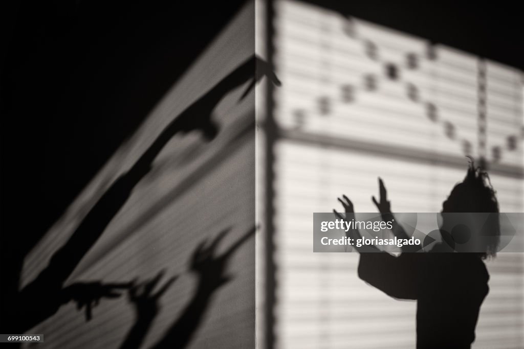 Silhouette of a scared girl with shadow monsters