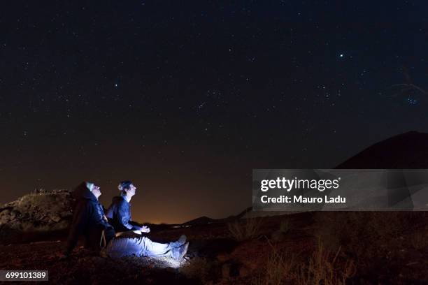 two young men watching the starry sky - astronomy photos et images de collection