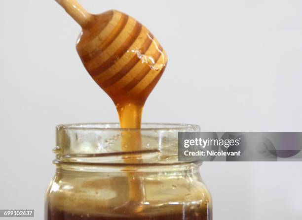 honey and honey dipper - honinglepel stockfoto's en -beelden