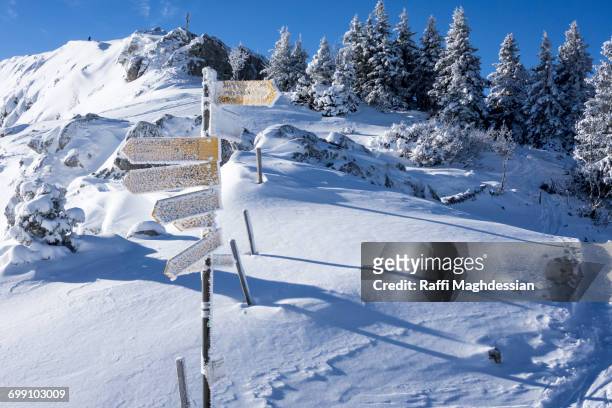a yellow hiking sign post lightly dusted with snow - wegweiser schweiz stock-fotos und bilder