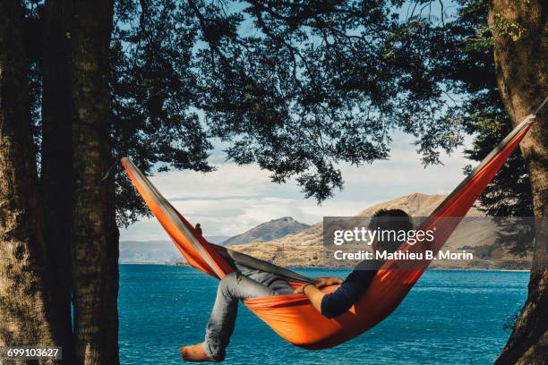 guy in hammock looking at the lake - hammock foto e immagini stock