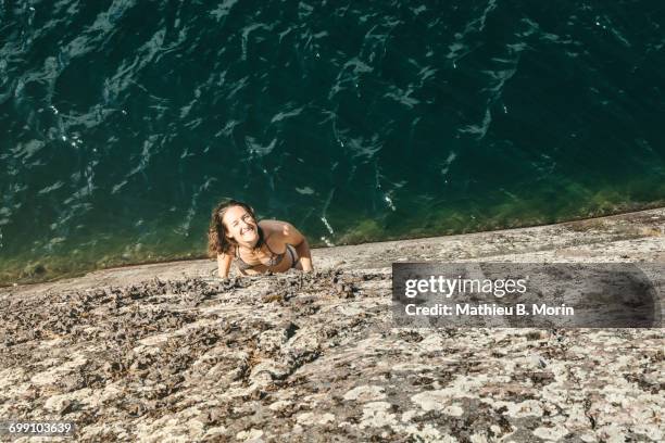 high angle view of smiling young woman looking up on a rock ledge - killarney canada stockfoto's en -beelden