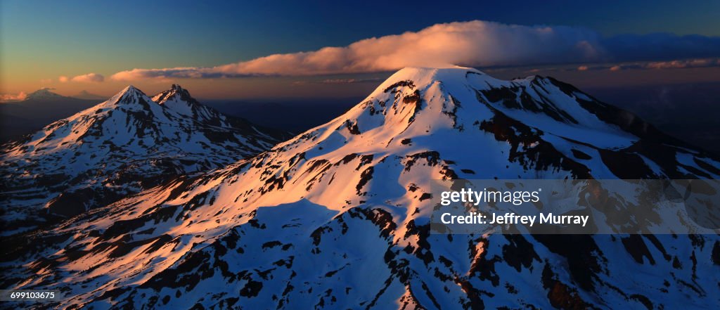An aeriel view of the Three Sisters with Mount Jefferson and Mount Hood in the distance.