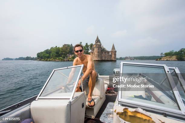 a man drives an old boat in the st. lawrence river in the 1000s islands of upstate new york. - 1000 2016 stock pictures, royalty-free photos & images