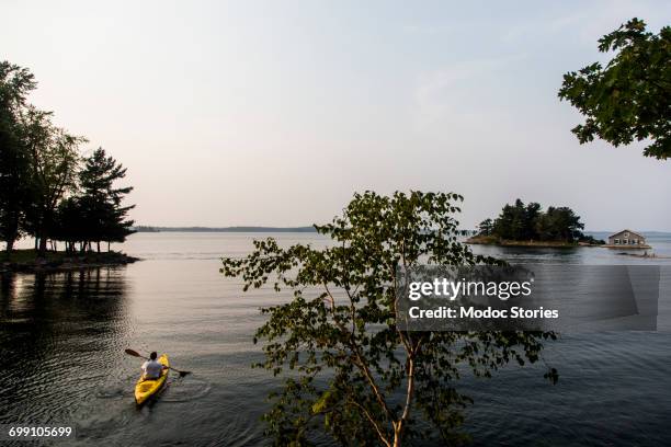 a man kayaks along the st. lawrence river in the 1000 islands of upstate new york. - sankt lorenz strom stock-fotos und bilder