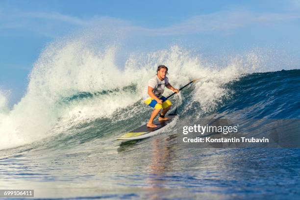 sup surfer on a wave - kuta stock pictures, royalty-free photos & images