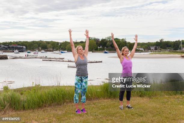 two women doing outdoor yoga - crecimiento estirón fotografías e imágenes de stock