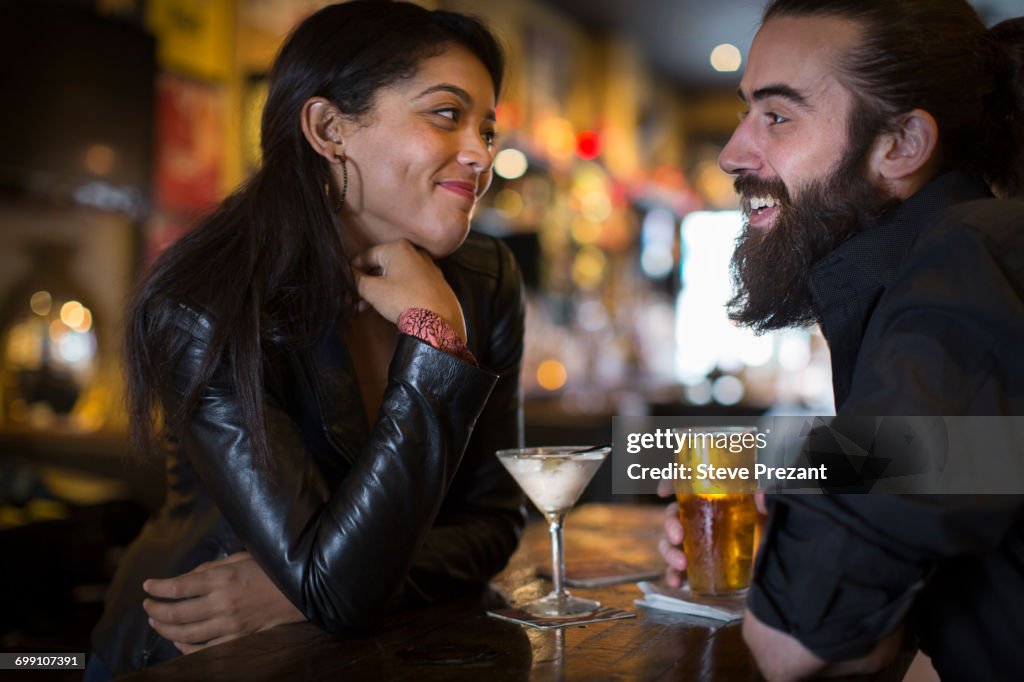 Romantic young couple with cocktail and beer in public house