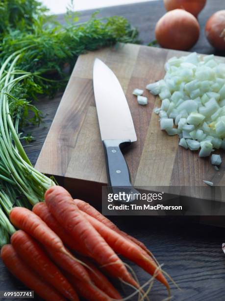fresh carrots with onions chopped on cutting board - halstock stock-fotos und bilder