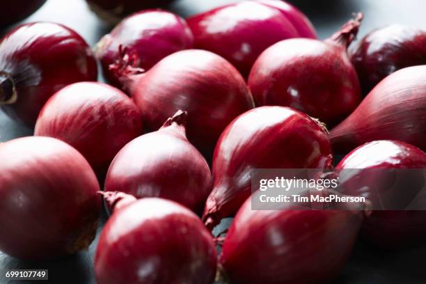 fresh whole red onions on table - halstock stock-fotos und bilder