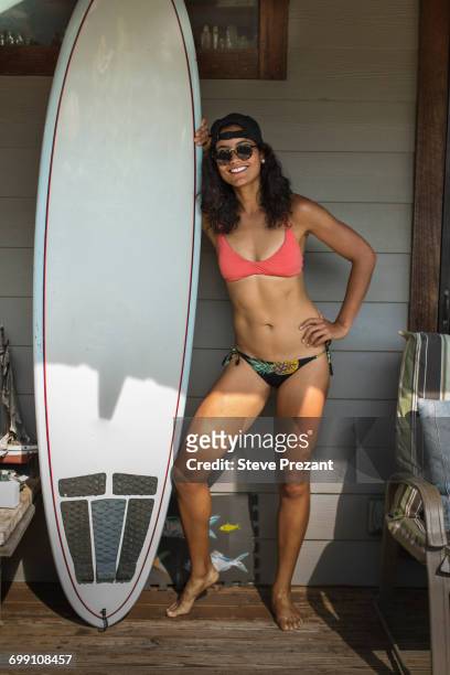 "portrait of young surfing woman standing on porch, rockaway beach, new york state, usa" - rockaway peninsula stockfoto's en -beelden