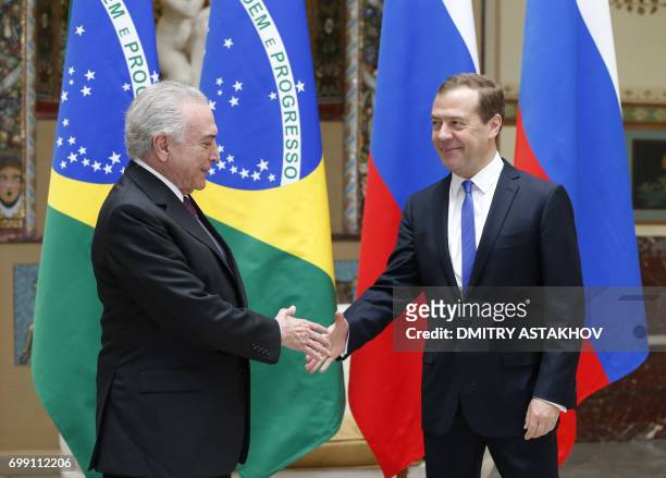 Russian Prime Minister Dmitry Medvedev shakes hands with Brazil's President Michel Temer during a meeting in Moscow on June 21, 2017. / AFP PHOTO /...