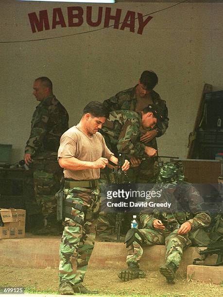Special forces soldier cleans his rifle just before the arrival of more U.S. Forces February 17, 2002 at the 103rd Brigade camp on the southern...