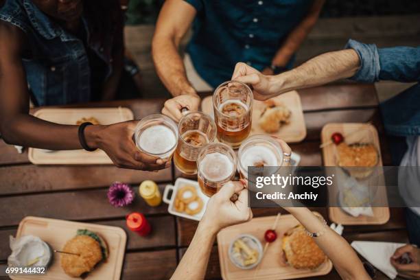 het verhogen van uw glazen voor een toast. - bier drinken stockfoto's en -beelden