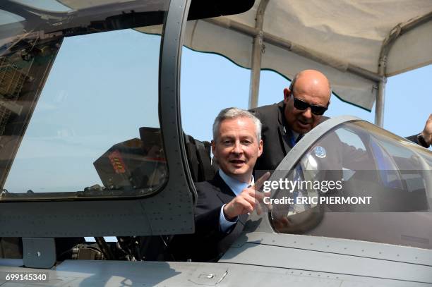 French Economy Minister Bruno Le Maire sits in French Dassault Aviation Rafale jetfighter flanked by Dassault Aviation Chief Executive and French...