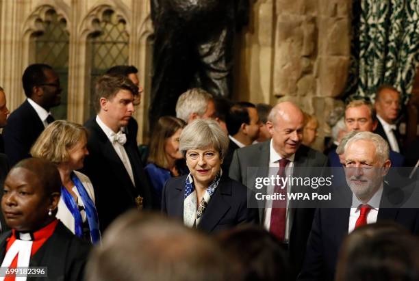 Britain's Prime Minister Theresa May, centre, and leader of the opposition Jeremy Corbyn, right, walk through the House of Commons to attend the...