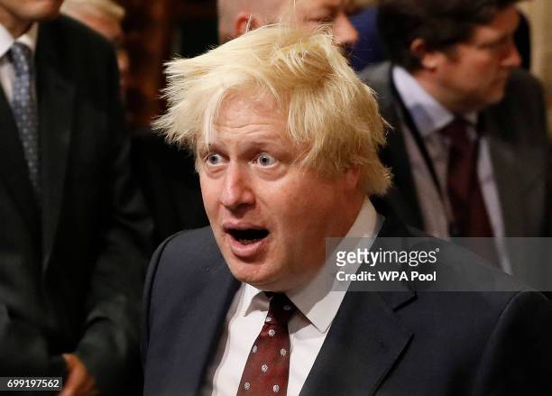 British Foreign Secretary Boris Johnson walks through the House of Commons to attend the the State Opening of Parliament taking place in the House of...