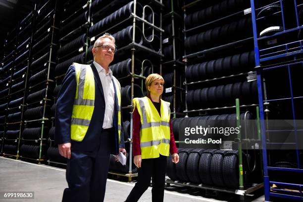 First Minister of Scotland Nicola Sturgeon is shown around by manager John Reid during a visit to the Michelin Tyre factory on June 21, 2017 in...
