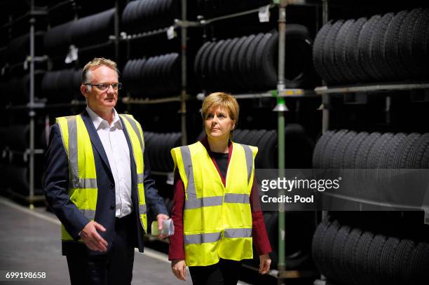 First Minister of Scotland Nicola Sturgeon is shown around by manager John Reid during a visit to the Michelin Tyre factory on June 21, 2017 in...