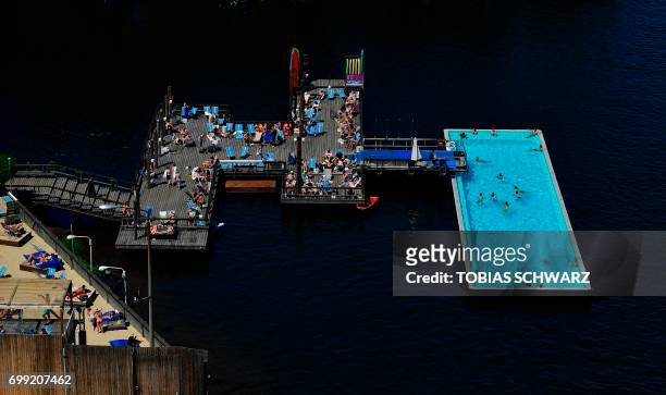 People swim in a pool at river Spree in Berlin on June 21, 2017. / AFP PHOTO / TOBIAS SCHWARZ