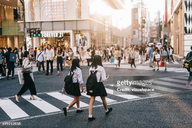 deux étudiants traversant la rue - nagoya stock photos et images de collection