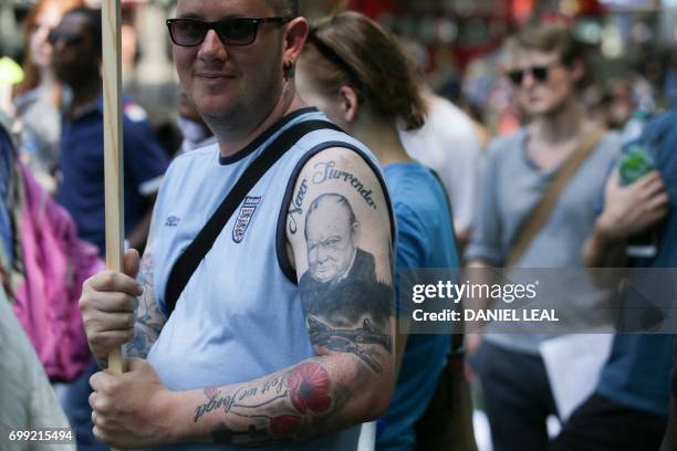 Man with a tattoo of former British prime minister Winston Churchill holds a placard as he joins demonstrators gathering in Shepherds Bush in west...