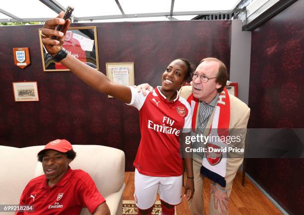 Danielle Carter of Arsenal Ladies poses with Former Arsenal player Charlie George on stage as they help introduce the new Arsenal Puma Home kit at...