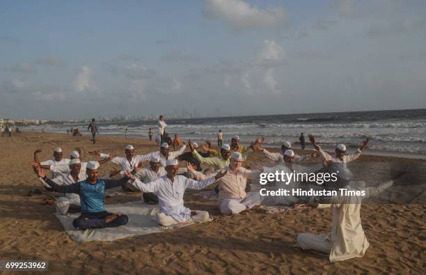 On the eve of World Yoga Day, Mumbai's Dabbawala celebrate the day by doing yoga exercises at Versova beach, on June 20, 2017 in Mumbai, India....