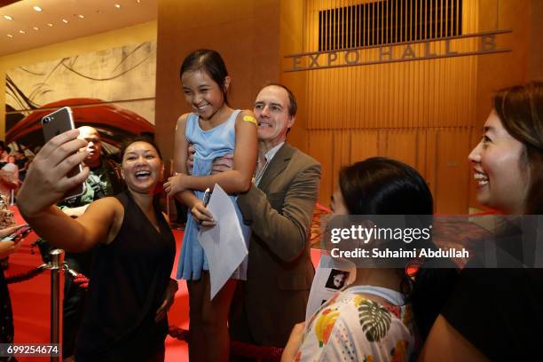 Kevin Doyle lifts up a young fan to pose for a photo during the Downtown Abbey: The Exhibition Red Carpet at the Sands Expo and Convention Centre on...