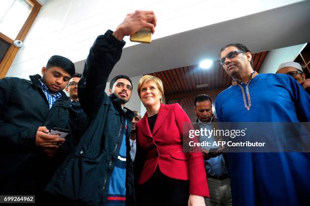 Scotland's First Minister and Scottish National Party leader Nicola Sturgeon poses for a "selfie" photograph as she meets worshippers during a visit...