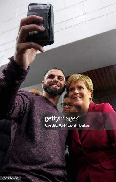 Scotland's First Minister and Scottish National Party leader Nicola Sturgeon poses for a "selfie" photograph as she meets worshippers during a visit...